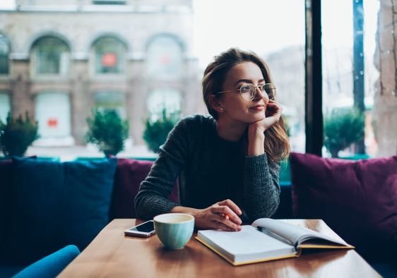 Woman writing her reflections in a journal.