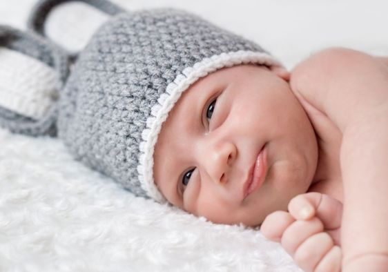 Cute newborn on a white blanket.