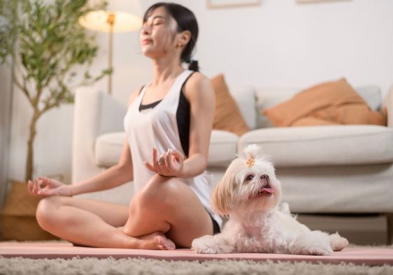 Woman meditating with her dog.