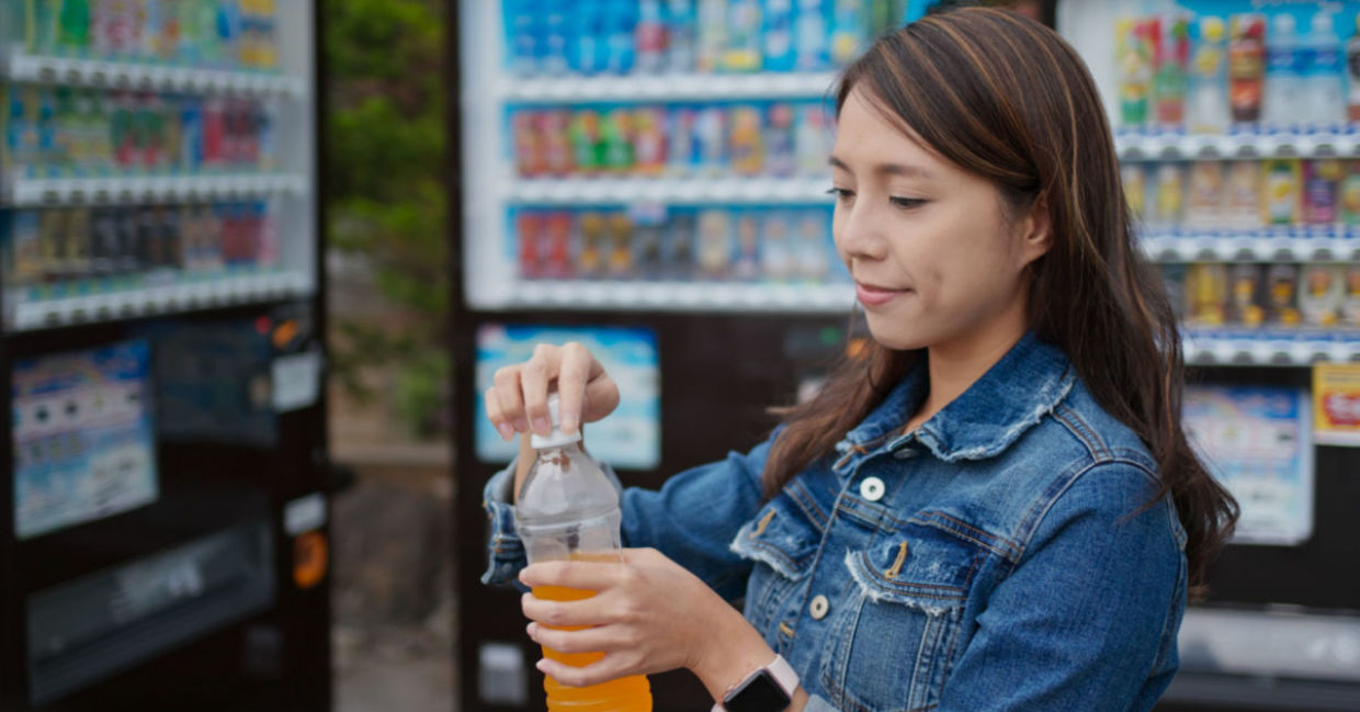 Woman purchasing a beverage from a vending machine.