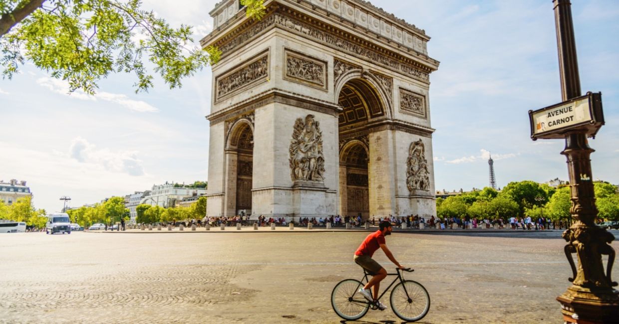 Man cycling near the Paris landmark Arc de Triomphe.