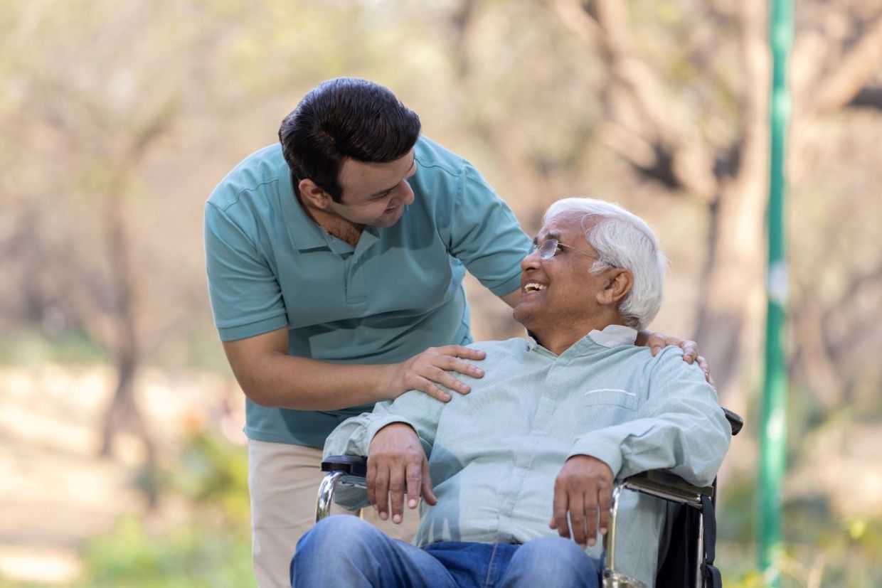 A young man helping a senior.