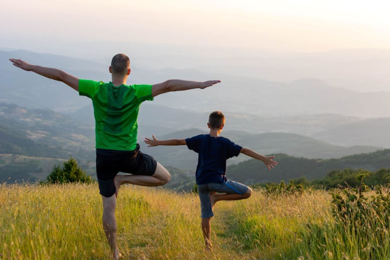 Father and son doing the tree pose.