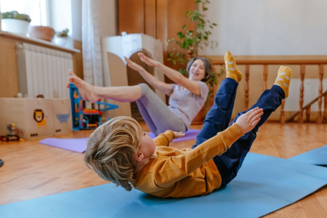 Child practicing yoga with grandmother.