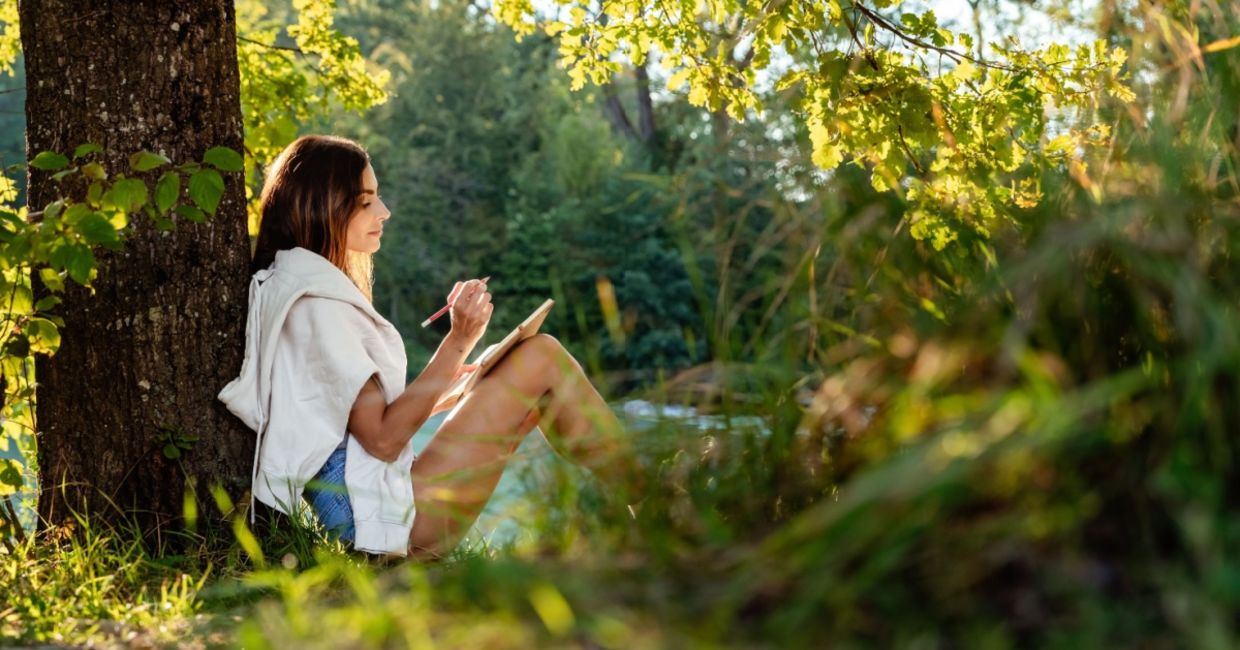 Woman journaling out in nature.