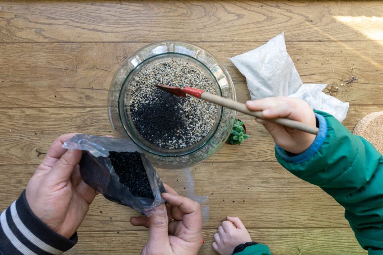 Using stones for drainage in a terrarium.