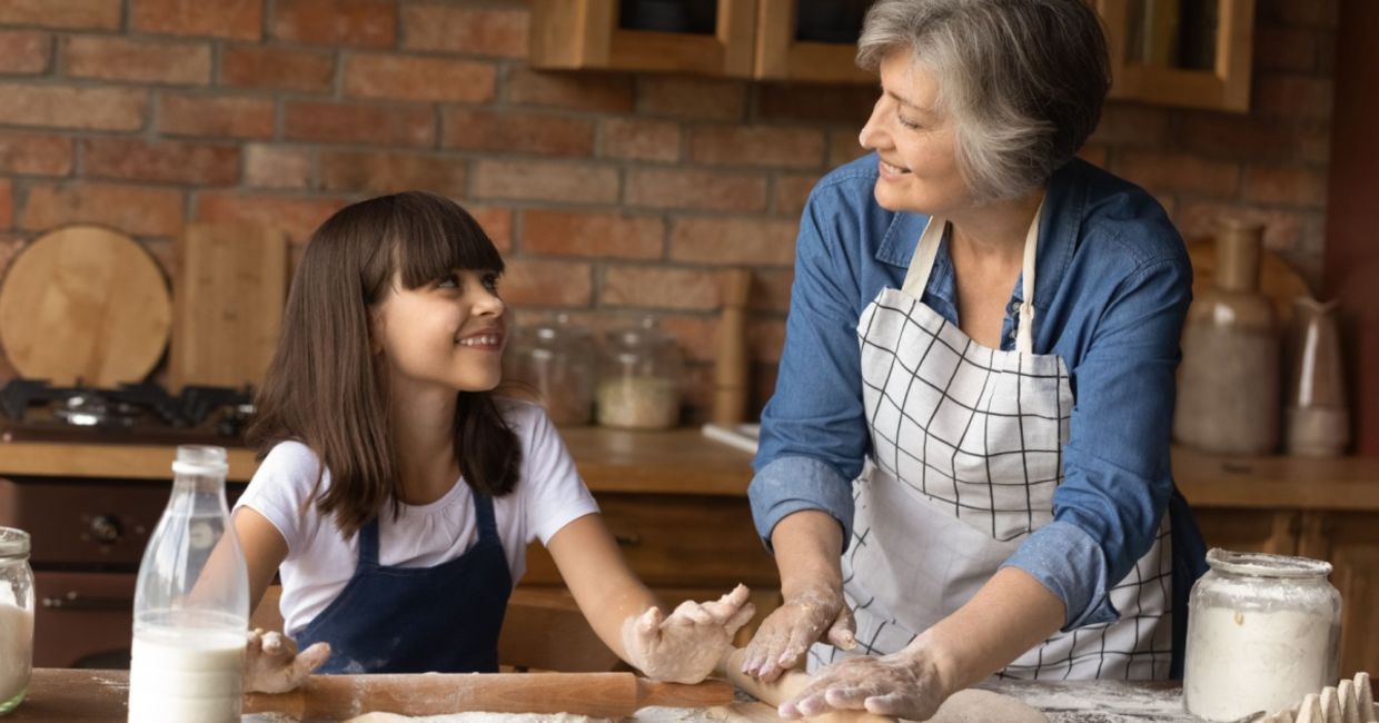 Grandmother teaching her granddaughter how to bake.