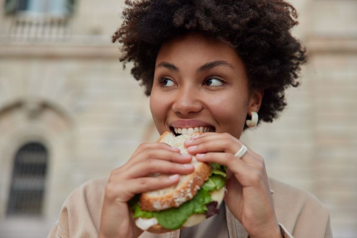 woman enjoying a sandwich for lunch.