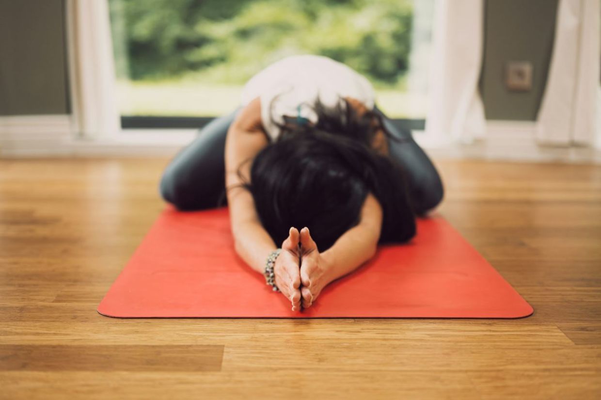 Woman in the child's yoga pose.