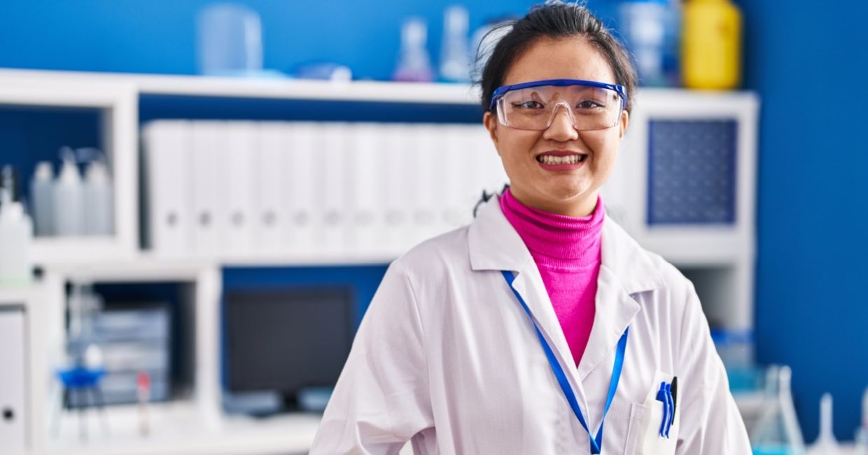 Young scientist in lab coat celebrating new research achievements.