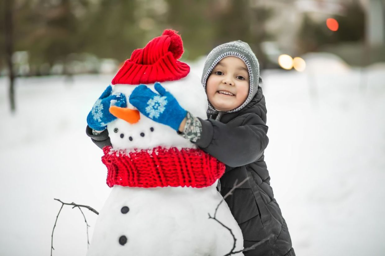 Adding the finishing touches to a snowman.