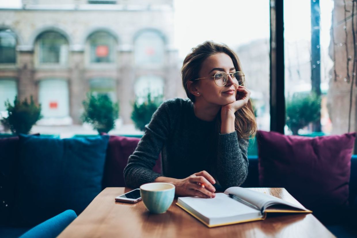 Woman writing her reflections in a journal.