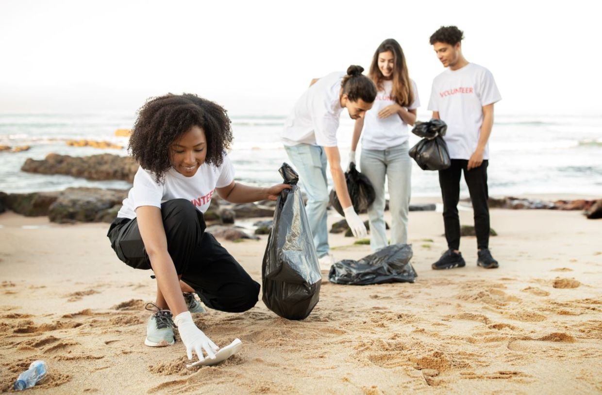 Young volunteers cleaning a beach.