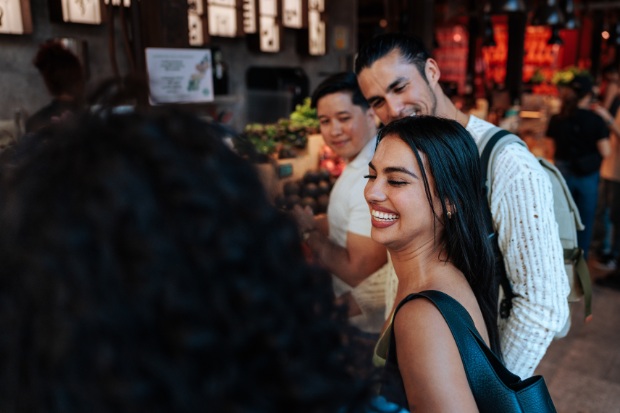 Happy tourists stand in a vibrant market.